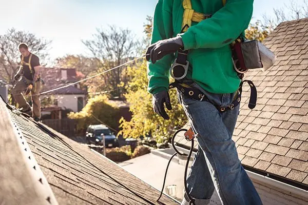 Tile and steel roofing work on a house roof